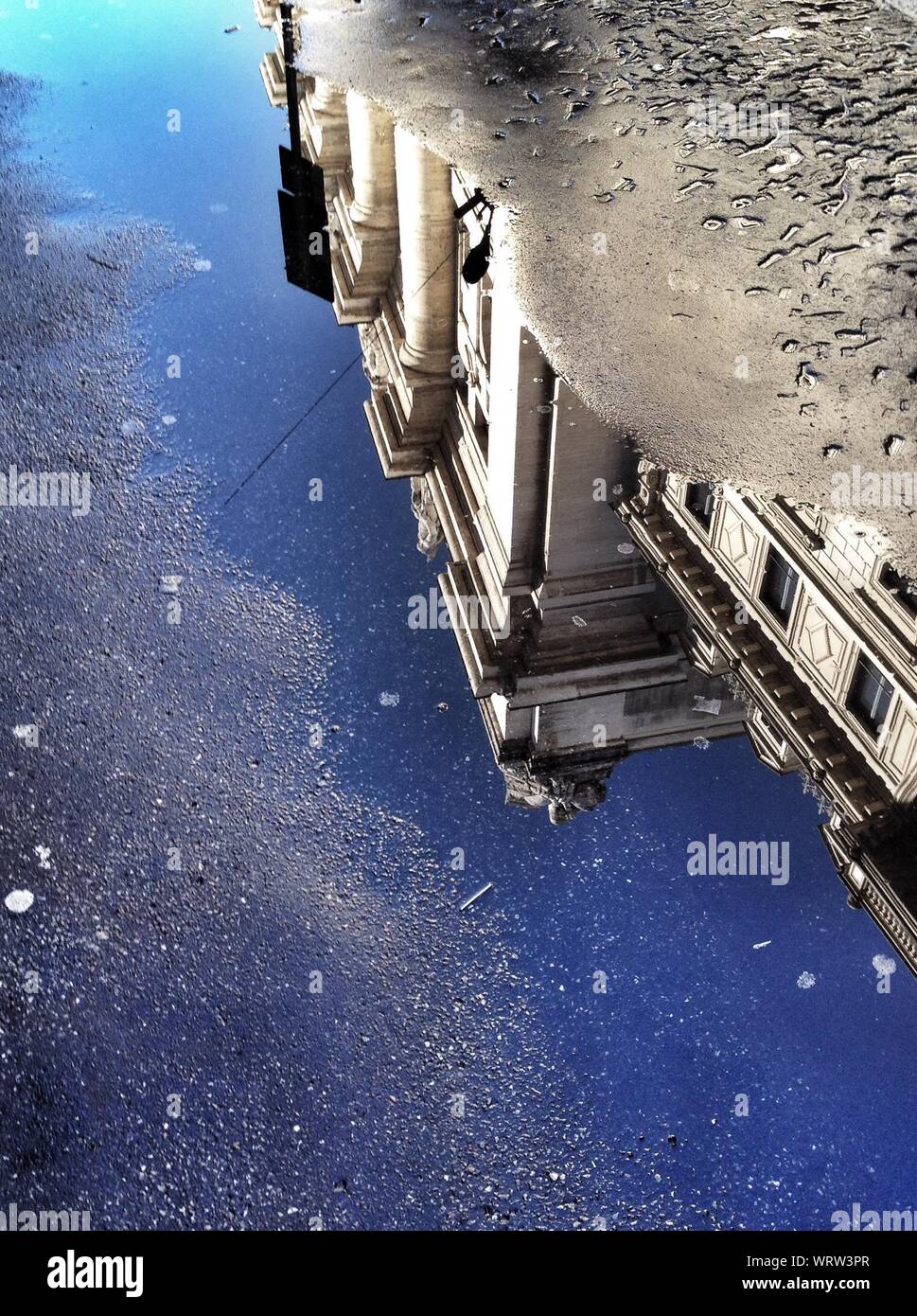 Reflection Of Building In Puddle On Street Stock Photo - Alamy