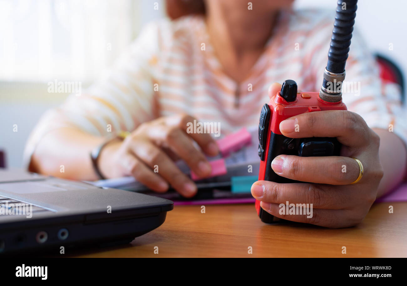 Female radio operator using Walkie - Talkie to communicate with other  people and working with document on working desk, Communication concept  Stock Photo - Alamy