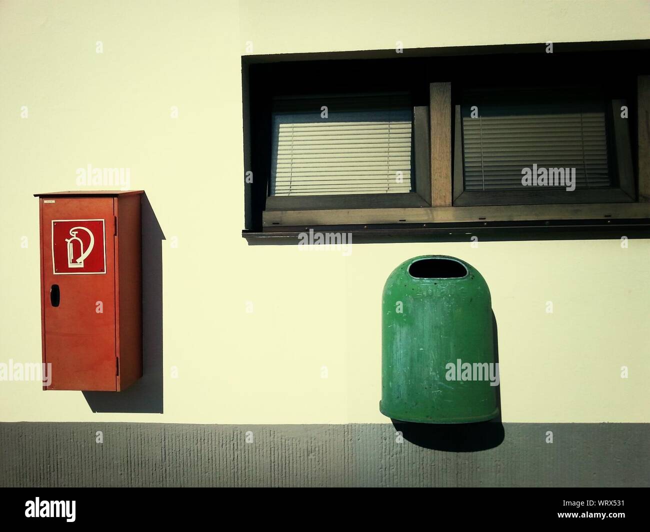 Fire Extinguisher And Garbage Can Stuck On Wall Stock Photo Alamy