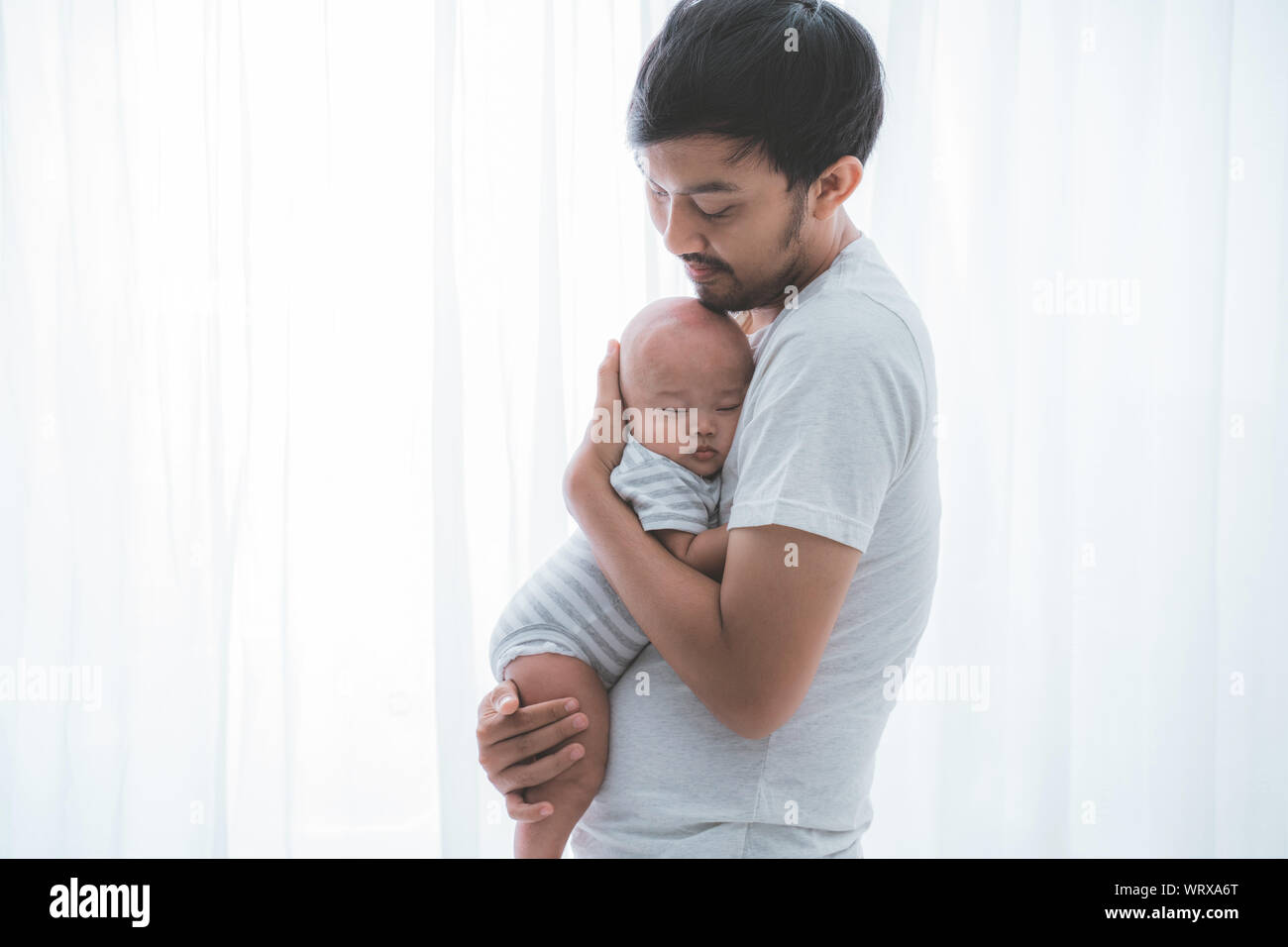 dad with his infant boy sleeping on his chest Stock Photo Alamy