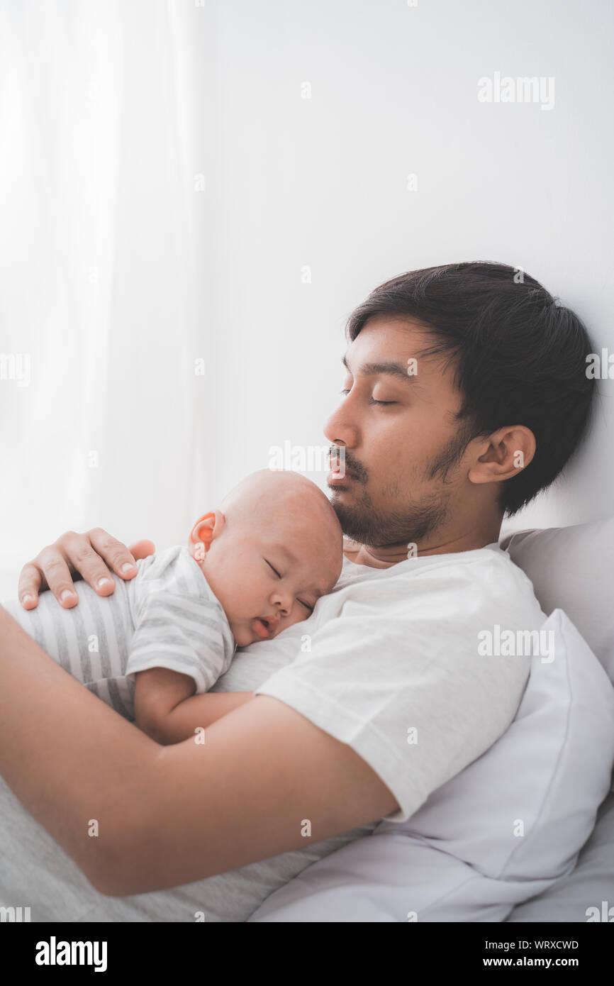 dad with his infant boy sleeping on his chest Stock Photo