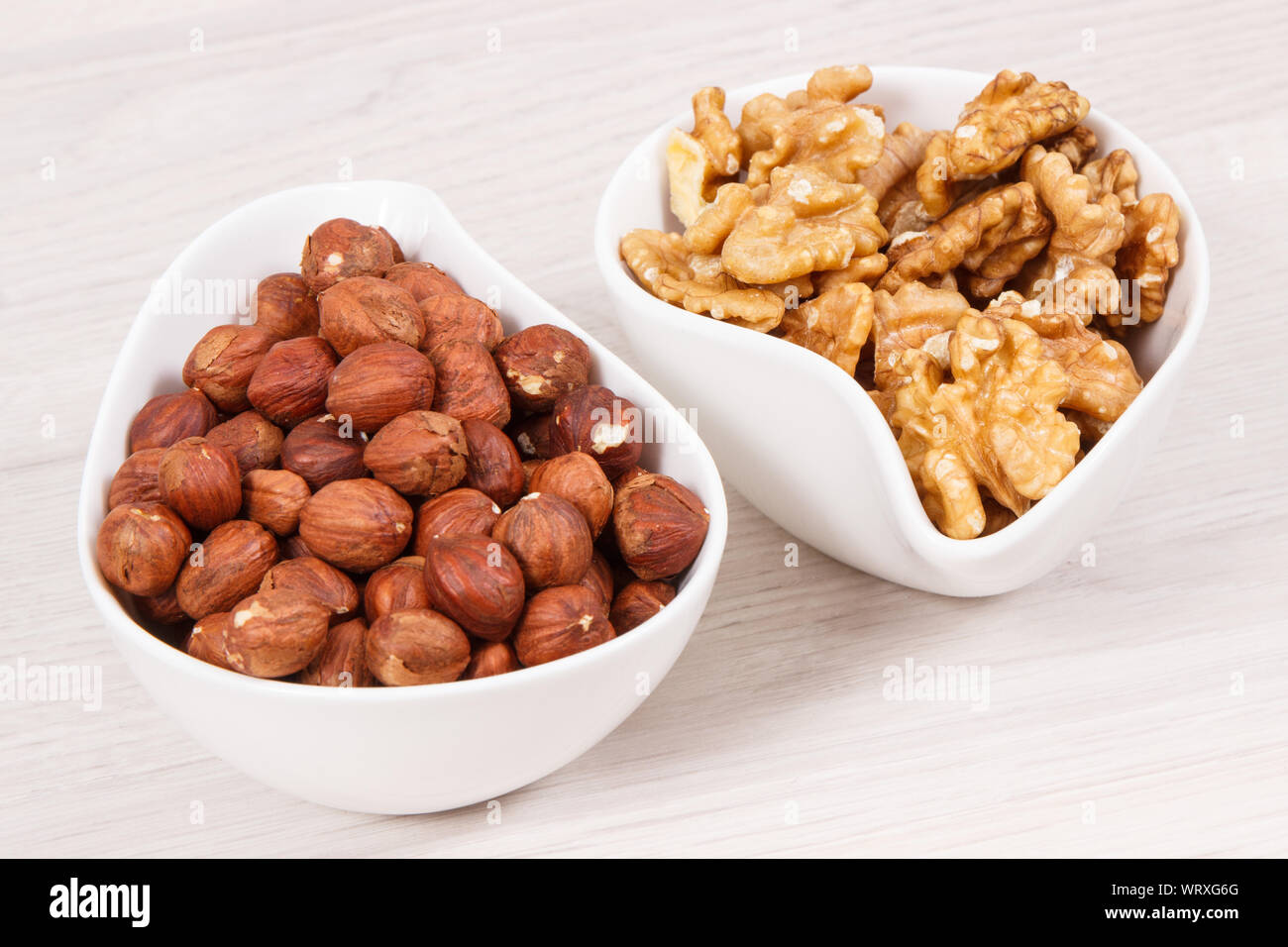 Hazelnuts and walnuts in white bowl as source healthy natural vitamins