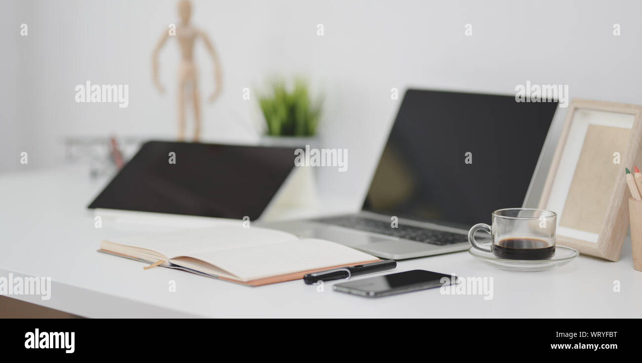 Open laptop computer with open notebook, office supplies and ...