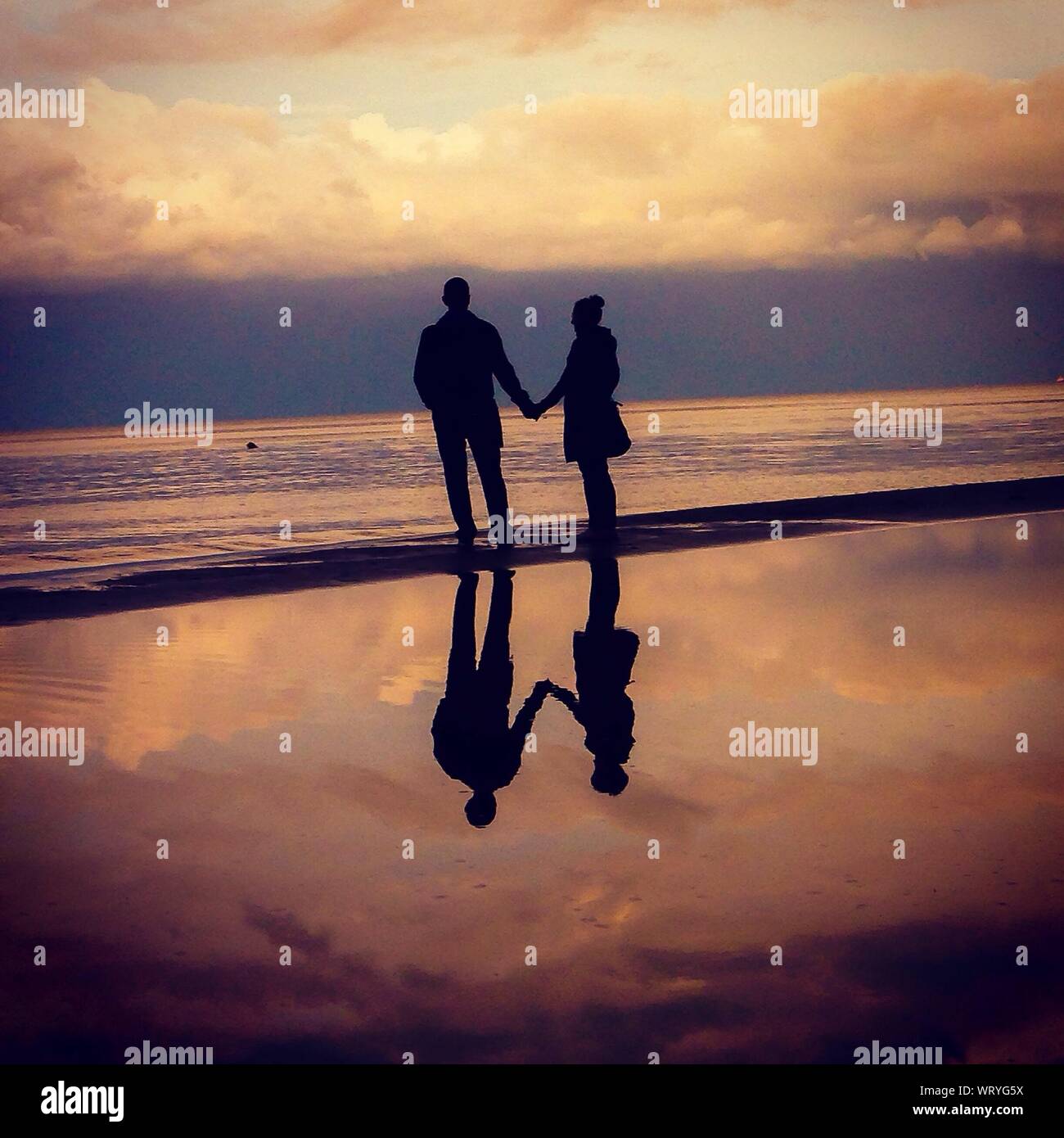Couple holding hands silhouette beach hi-res stock photography and ...