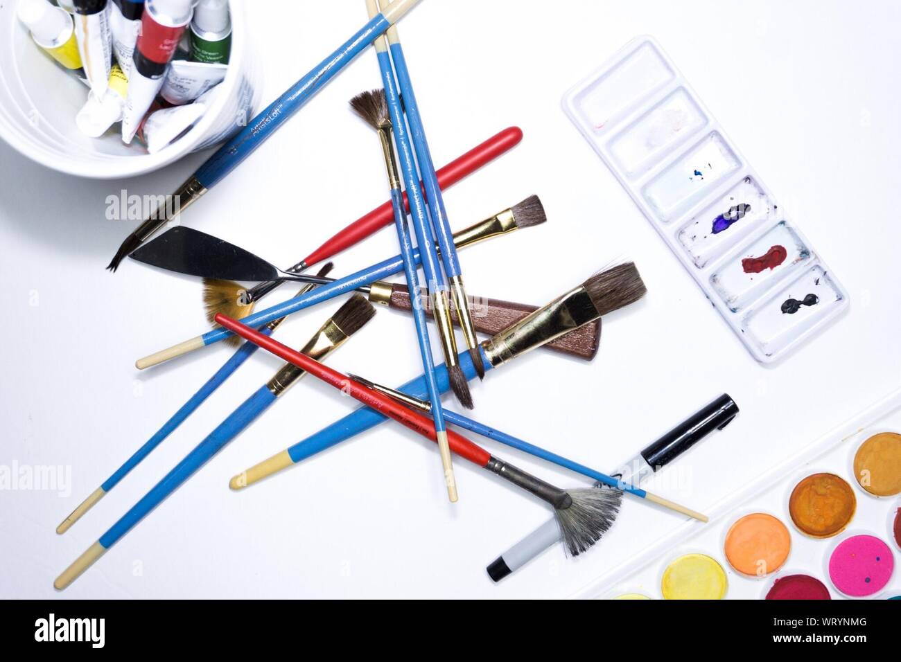 High Angle View Of Watercolor Paints And Brushes On Table Stock Photo
