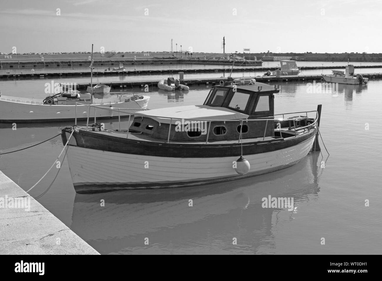 black and white image of a vintage wooden boat moored in the port of Numana near Ancona on the Adriatic Sea in Italy Stock Photo