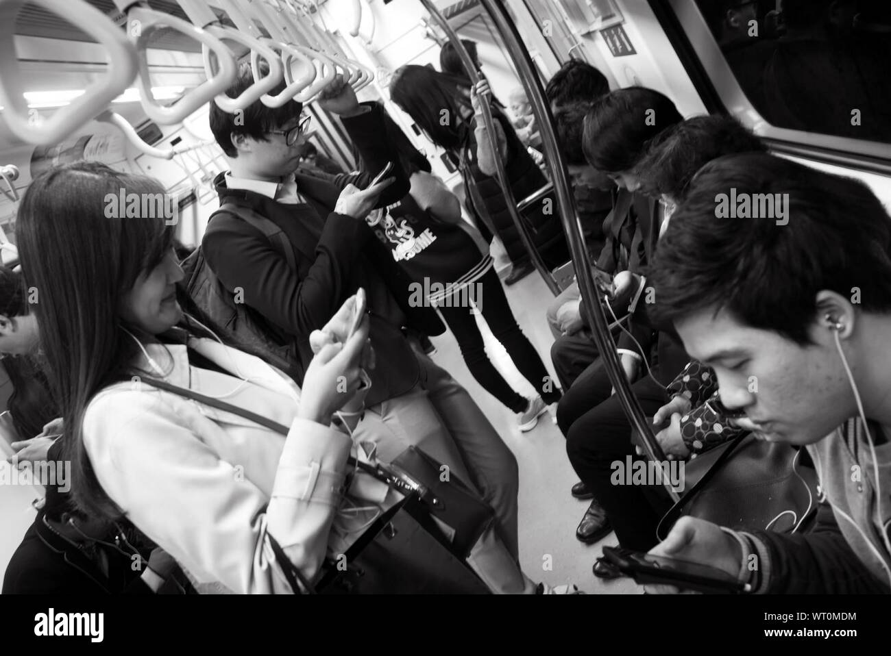 People Using Cell Phones While Traveling In Train Stock Photo