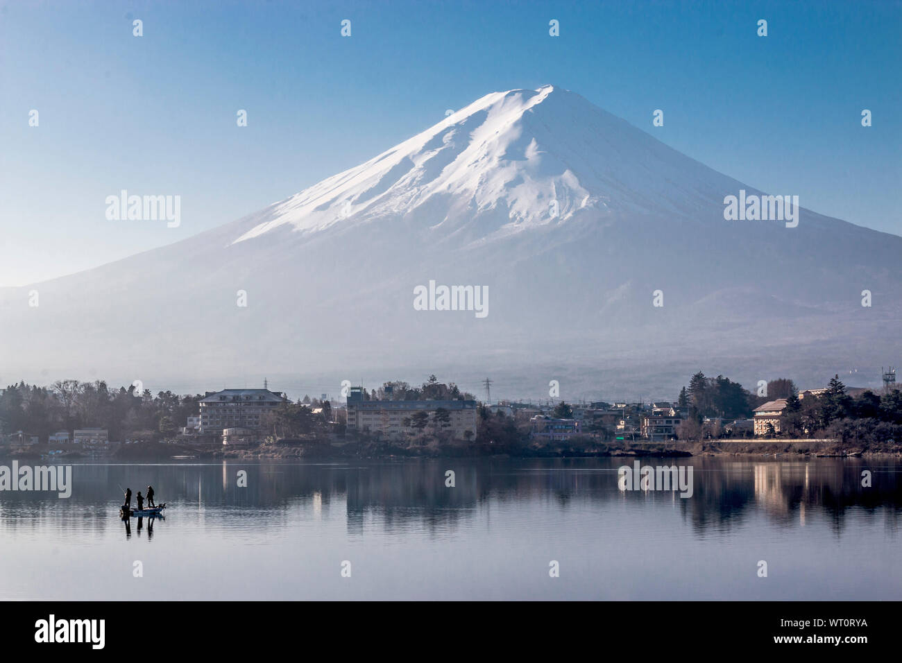 View of Mount Fujisan from Lake Kawaguchi in the morning with 3 men fishing in the lake Stock Photo