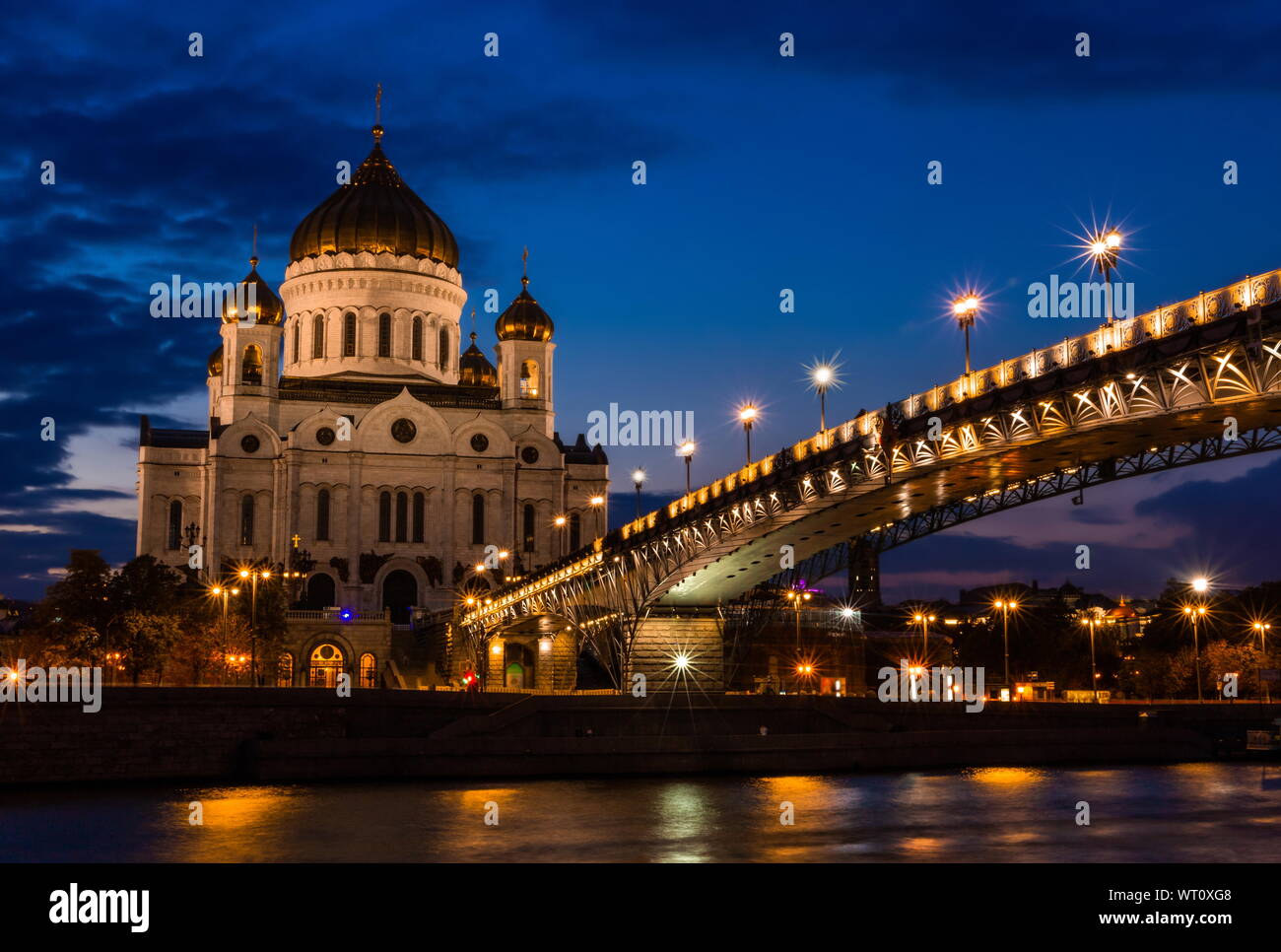 Illuminated Cathedral of Christ the Savior framed with old style street lights of Patriarchy Bridge at night. Stock Photo