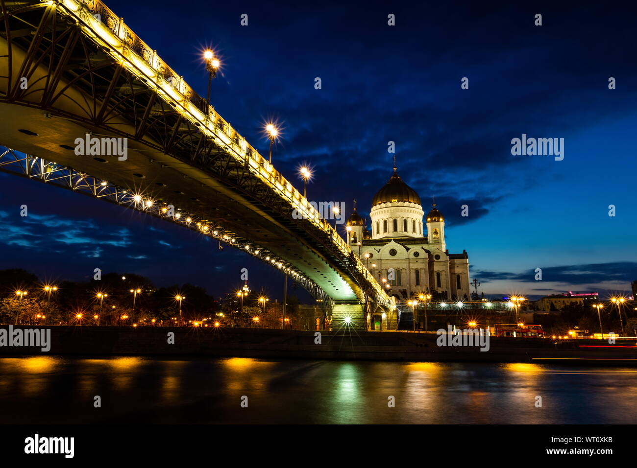 Illuminated Cathedral of Christ the Savior framed with old style street lights of Patriarchy Bridge at night. Stock Photo