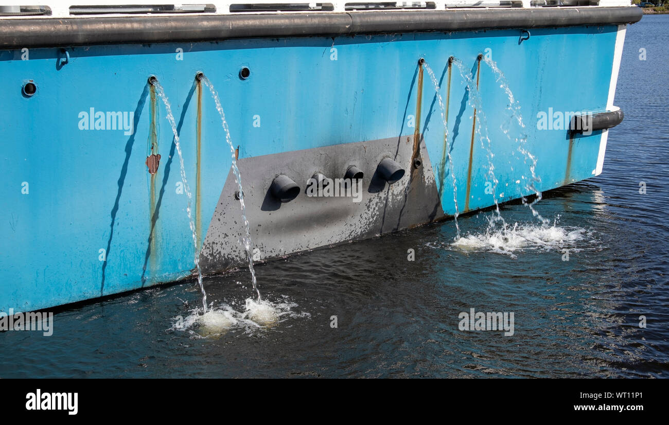 Water coming out from a ship stern for cooling the engine Stock Photo