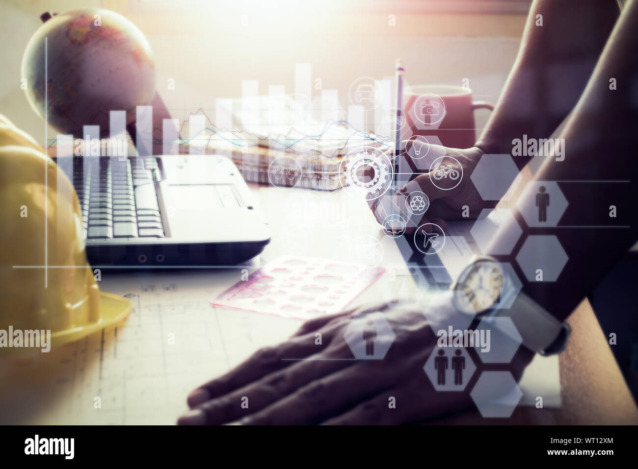 Hands of architect drawing construction plan on office desk with virtual graphic icon diagram. Stock Photo