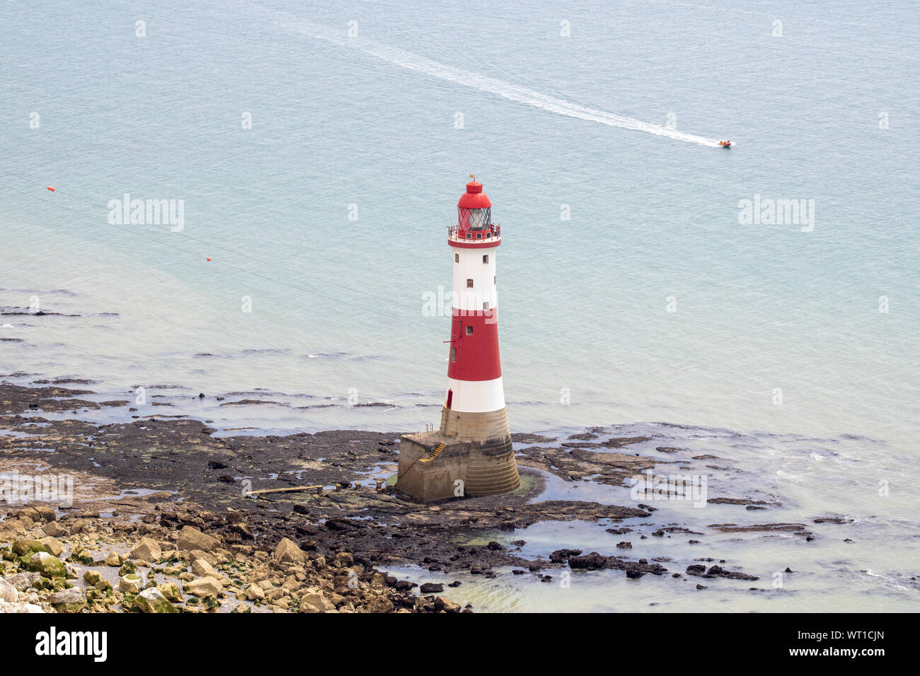 The famous Beachy Head lighthouse located on the rocky beach of Beachy Head the chalk headland cliff in East Sussex showing a typical British light ho Stock Photo
