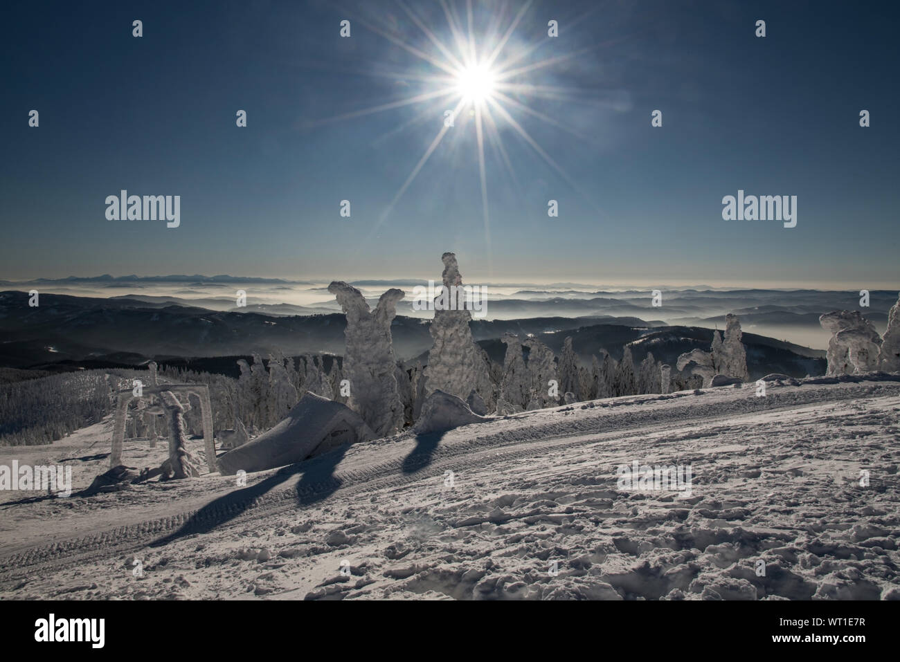 spectacular view with many mountain ranges, sun with clear sky and fog in valleys from Lysa hora hill in winter Moravskoslezske Beskydy mountains in C Stock Photo