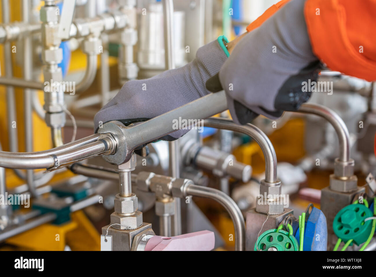 A mechanic operator fix and tighten stainless steel tubing system by using combination wrench, offshore oil and gas industry maintenance and service Stock Photo