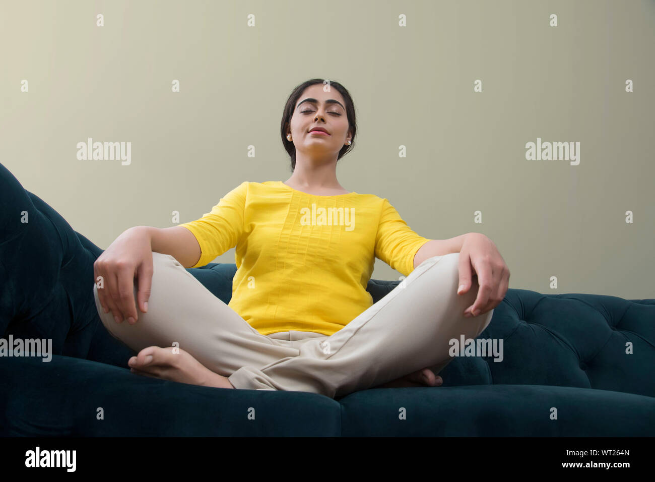 young woman sitting on the sofa with her eyes closed Stock Photo - Alamy