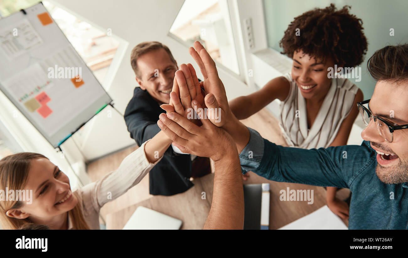 Well done Business people giving each other high-five and smiling while working together in the modern office. Teamwork. Success Stock Photo