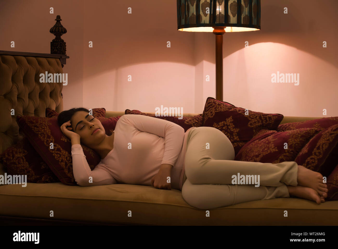 young woman sleeping on day bed Stock Photo
