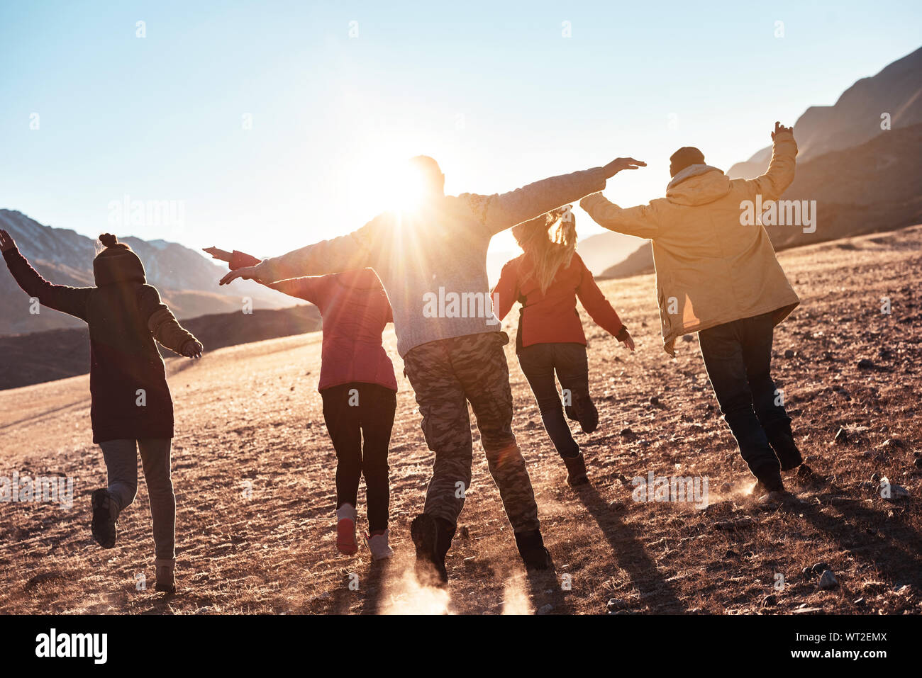 Happy friends having fun and runs at sunset. Togetherness or freedom concept Stock Photo