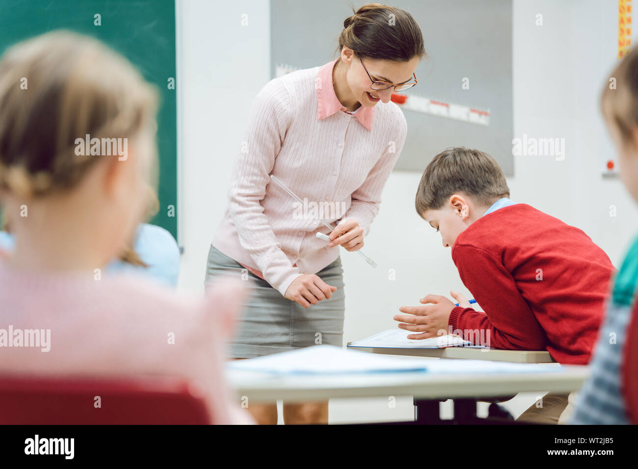 Teacher woman talking to student in class room Stock Photo