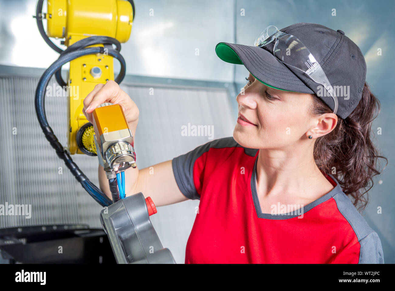 A young female technician while machine constructing in a manufacturing plant Stock Photo