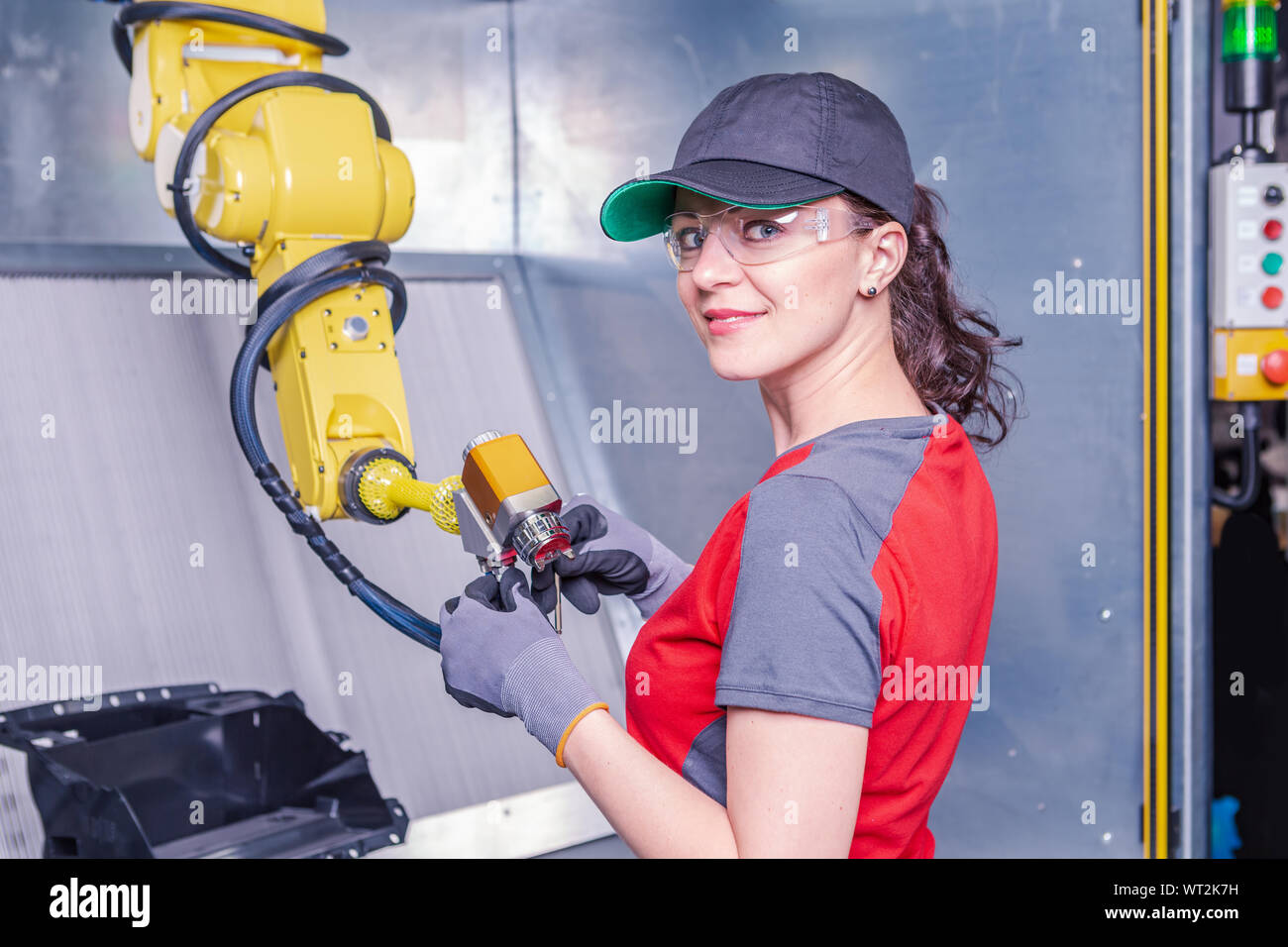 A young female technician while machine constructing in a manufacturing plant Stock Photo