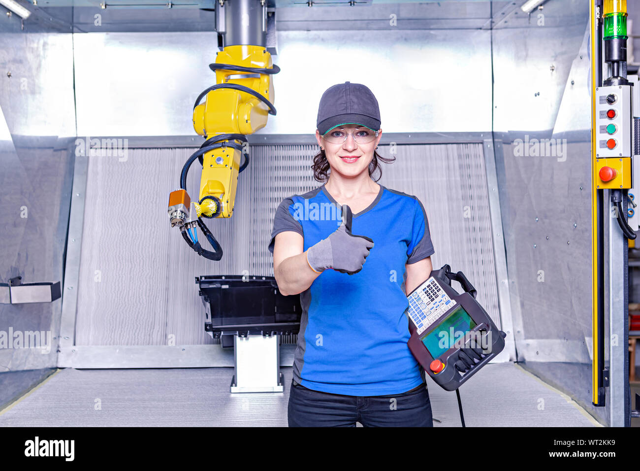A young female technician while machine constructing in a manufacturing plant Stock Photo