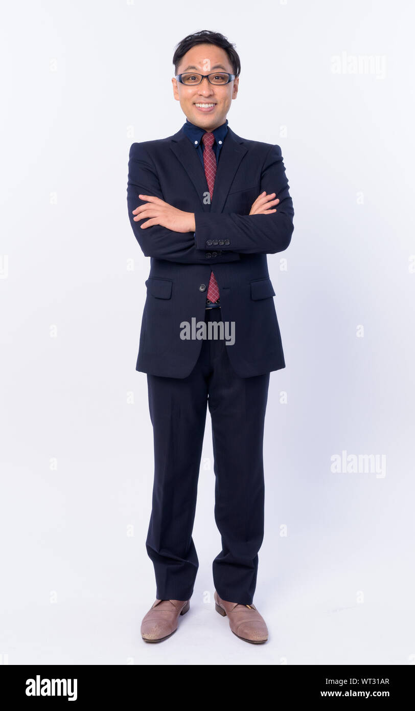 Full body shot of happy Japanese businessman in suit smiling with arms ...