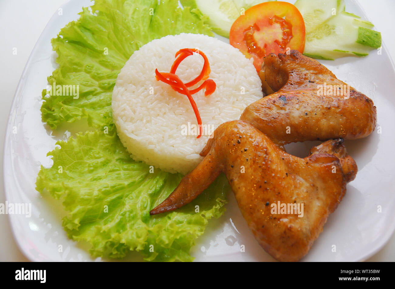 Vietnamese food fried chicken wings rice with salad and tomato slice