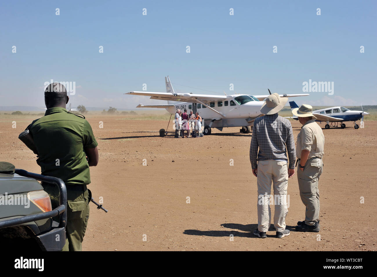 Airplane and tourists at Olkiombo Airstrip, Masai Mara, Kenya Stock Photo