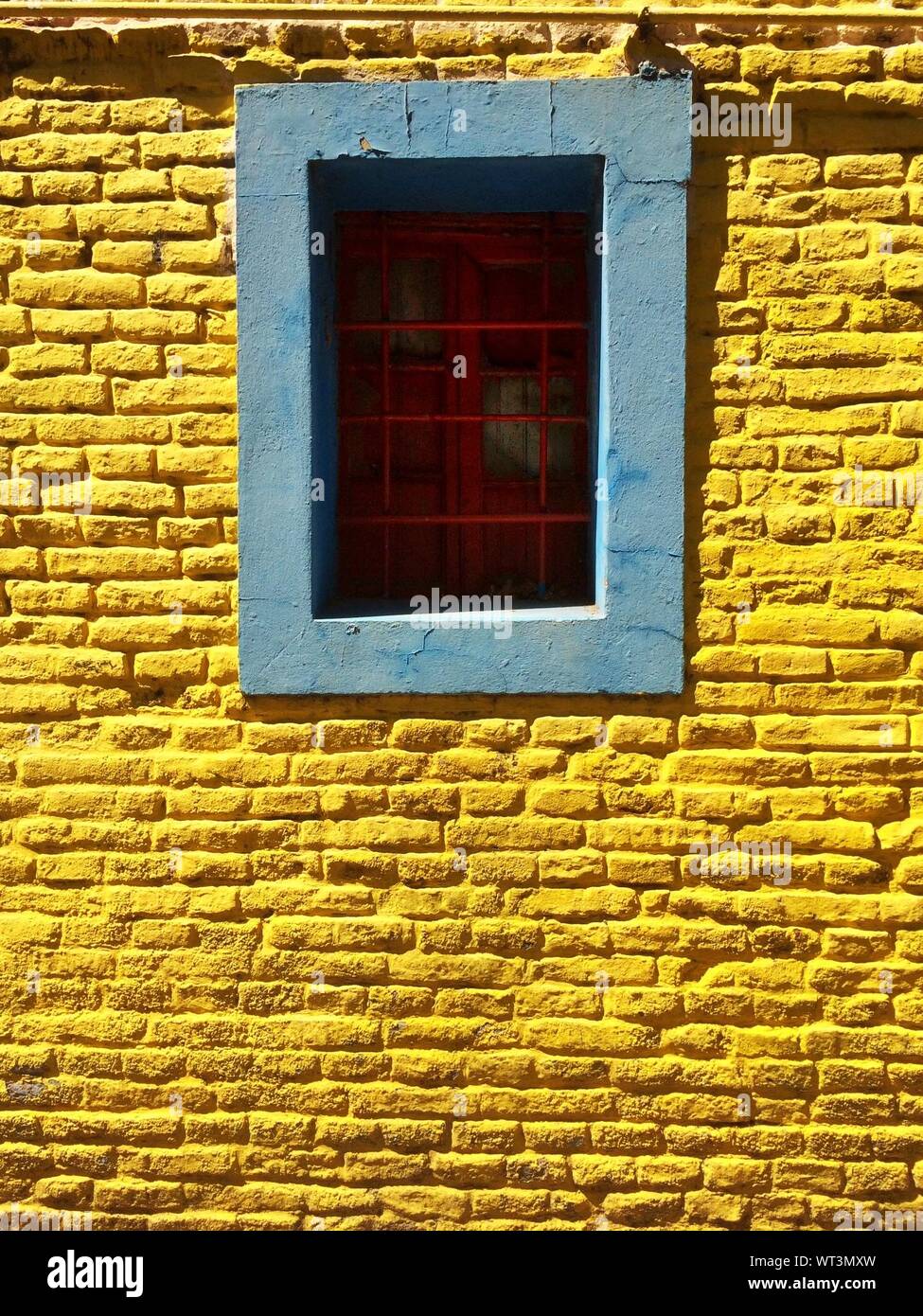Window On Yellow Brick Wall Stock Photo