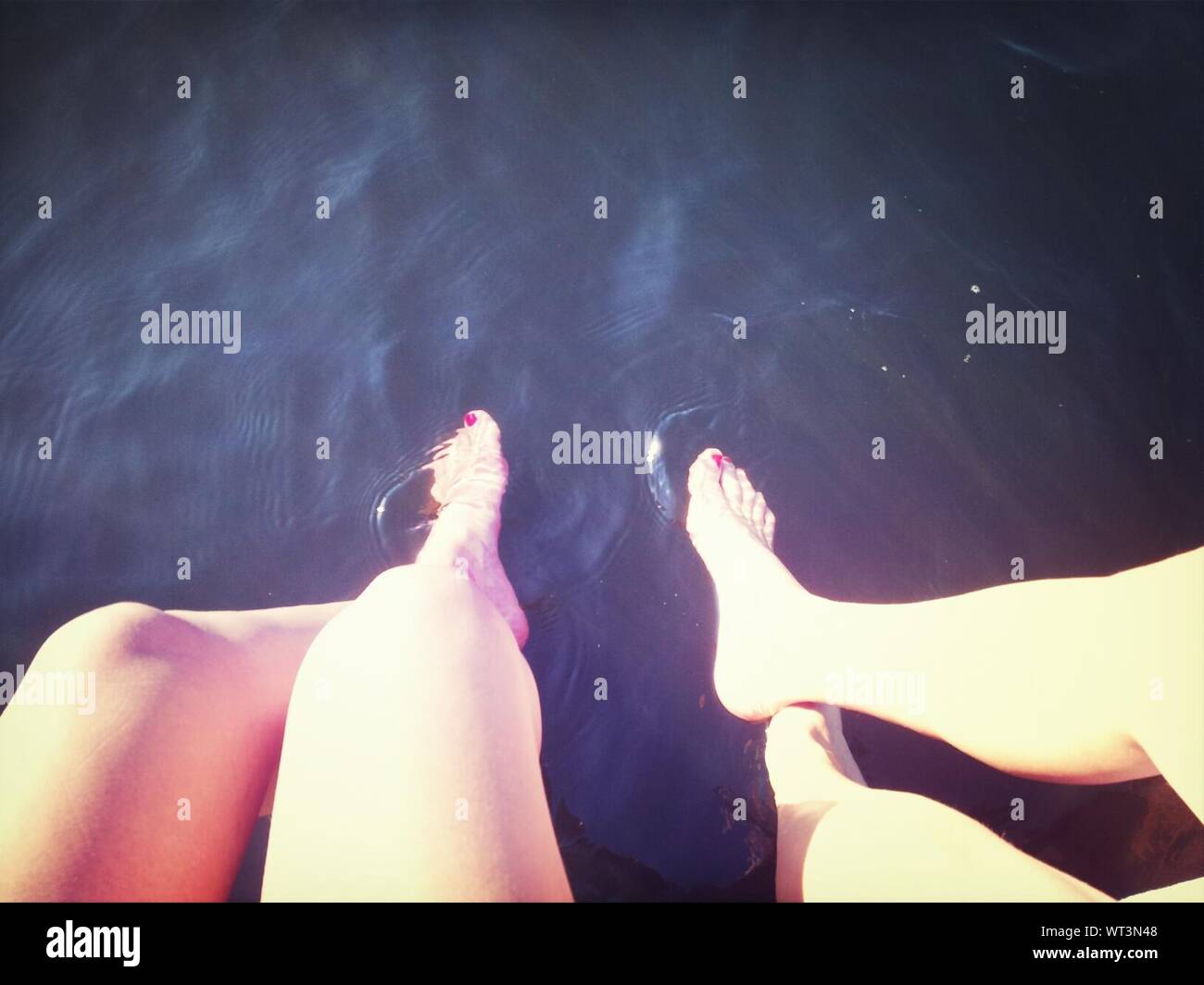Two Women Wetting Their Legs In Waters Stock Photo