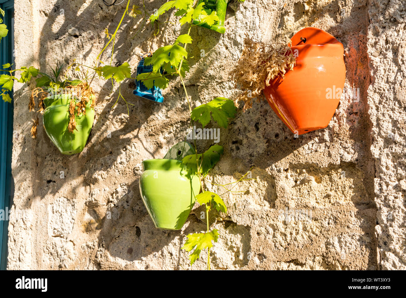 Colourful plant pots hanging on a wall in Alacati, Izmir, Turkey Stock Photo