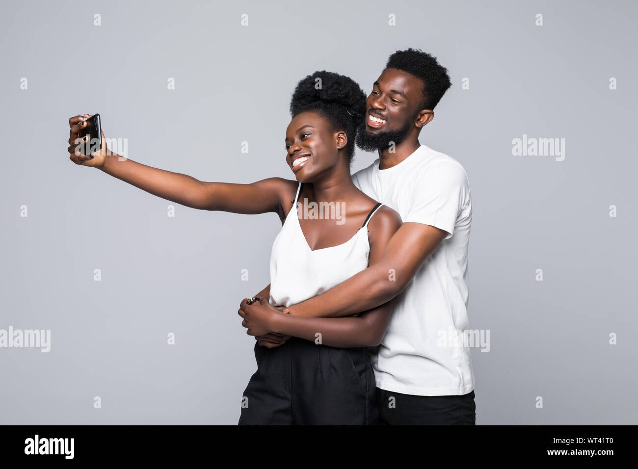 Portrait of a two joyful young african couple isolated over white ...