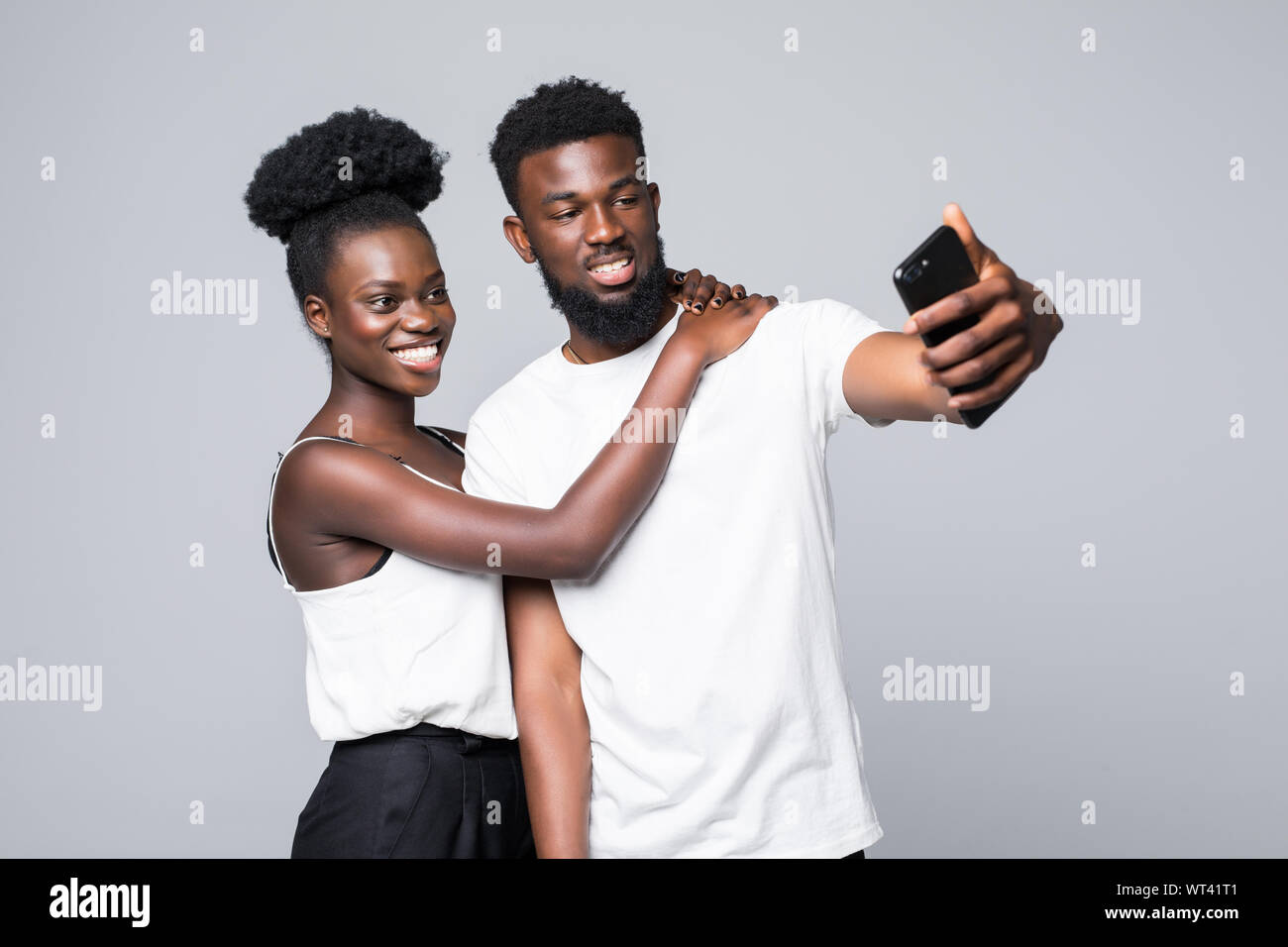 Portrait of a two joyful young african couple isolated over white ...