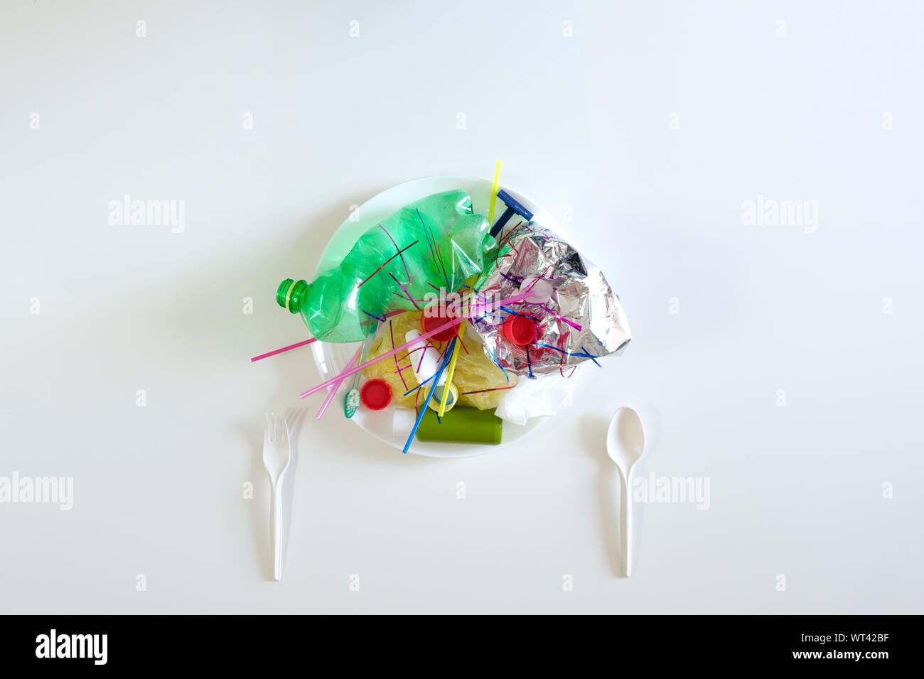 Plastic trash on a plate. The concept of environmental pollution with plastic waste and the danger of microplastics for human health Stock Photo