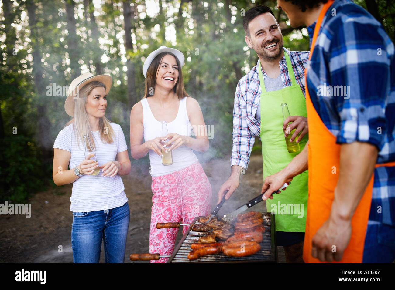 Group of happy friends having a barbecue party in nature Stock Photo ...