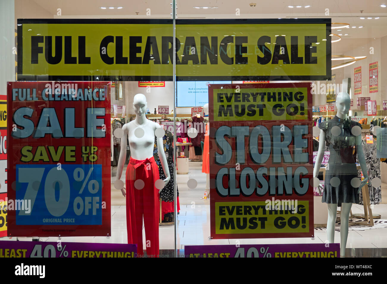 Store closing and everything must go sale signs in the window of ...