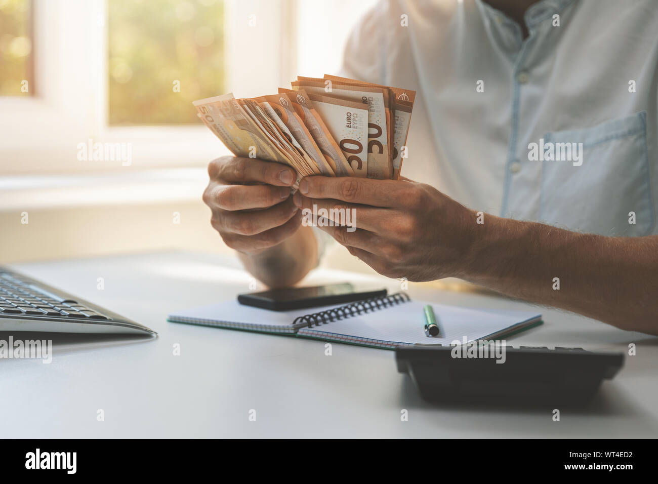 business success - businessman counting cash money in the office Stock Photo