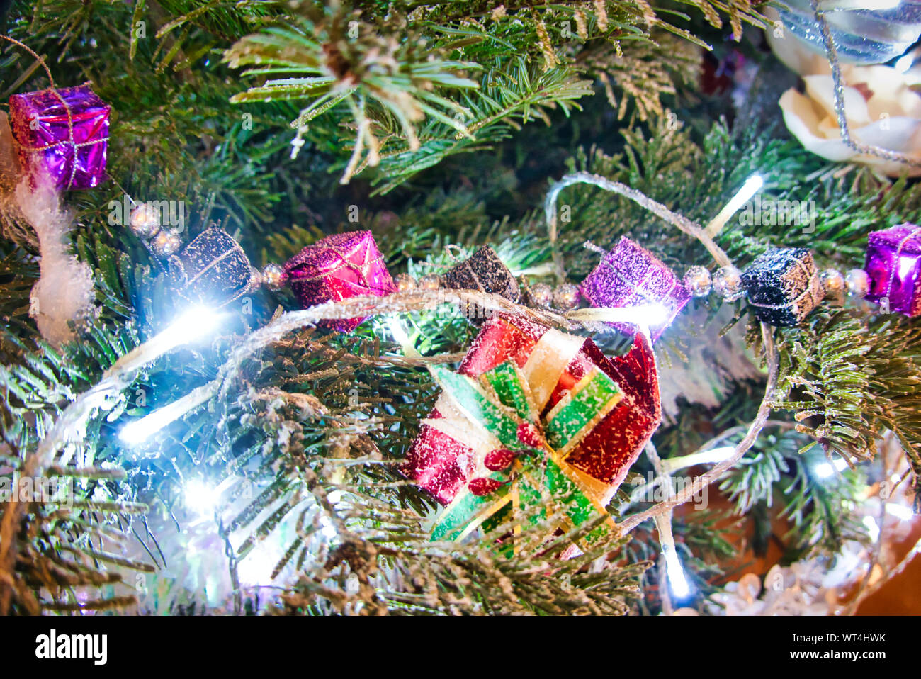 Christmas tree with red purple and white toys and flowers in the ...