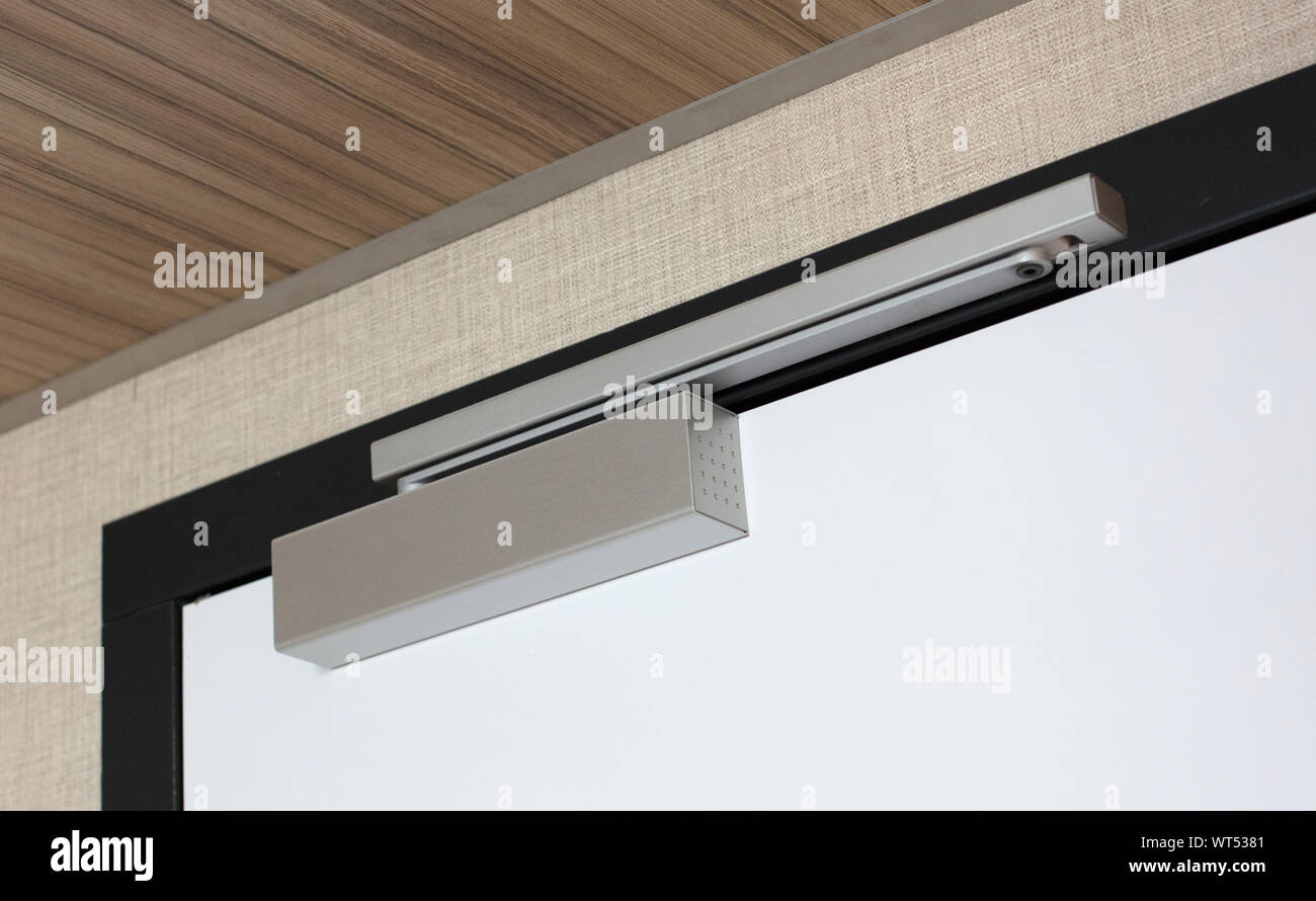 Door closing mechanism on a big white door Stock Photo Alamy