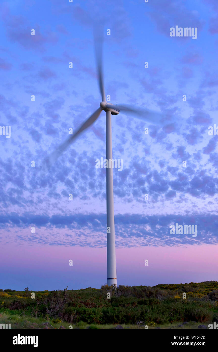 Wind Turbine On Landscape Against Blue Sky Stock Photo