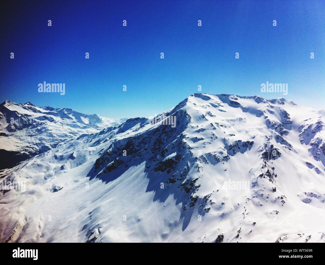 Idyllic View Of Snowcapped Mountain Against Blue Sky In Bormio Stock Photo