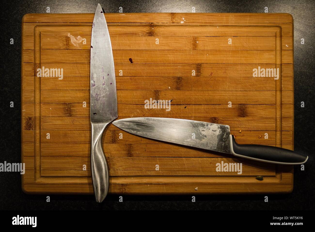 Directly Above Shot Of Kitchen Knives On Cutting Board Stock Photo