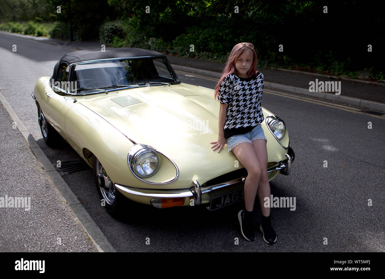 Sonya Maltseva, (Russia), sitting on Jaguar E-type Jaguar motor car in road in Beckenham, Kent, England Stock Photo