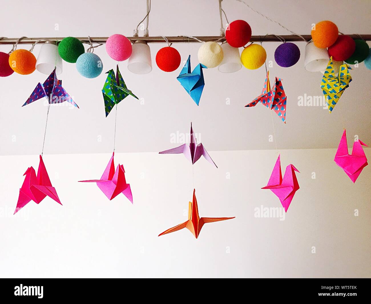 Low Angle View Of Colorful Origami Cranes Hanging From Ceiling Stock
