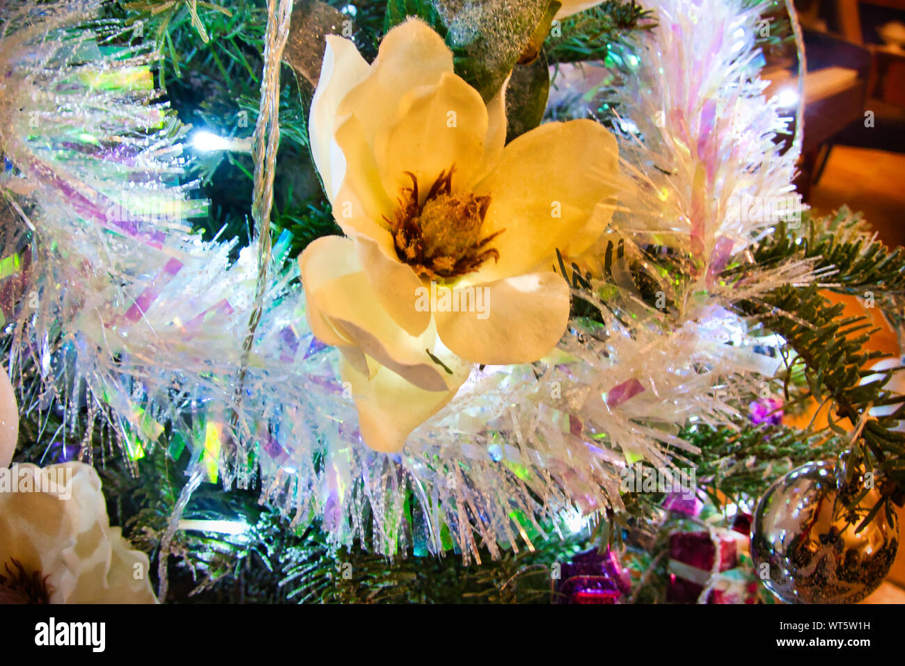 Christmas tree with red purple and white toys and flowers in the ...