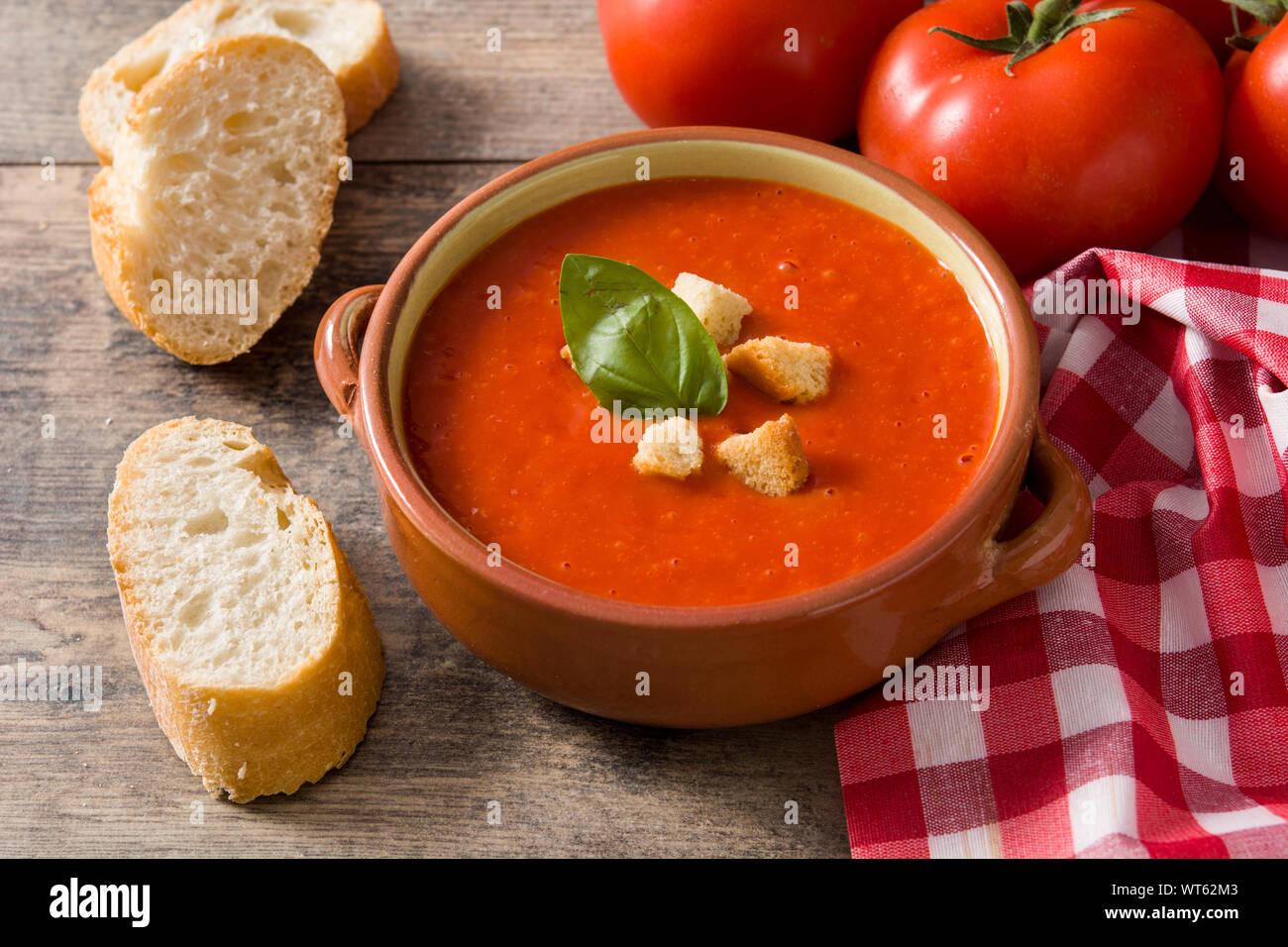 Tomato soup in brown bowl on wooden table Stock Photo