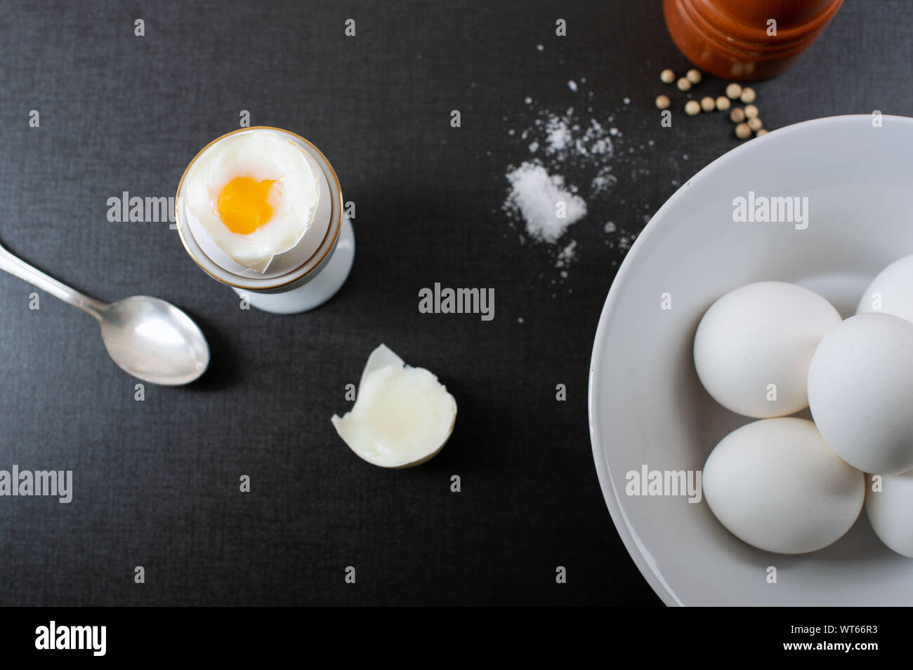 Boiled organic eggs with sea salt and white pepper on black background Stock Photo