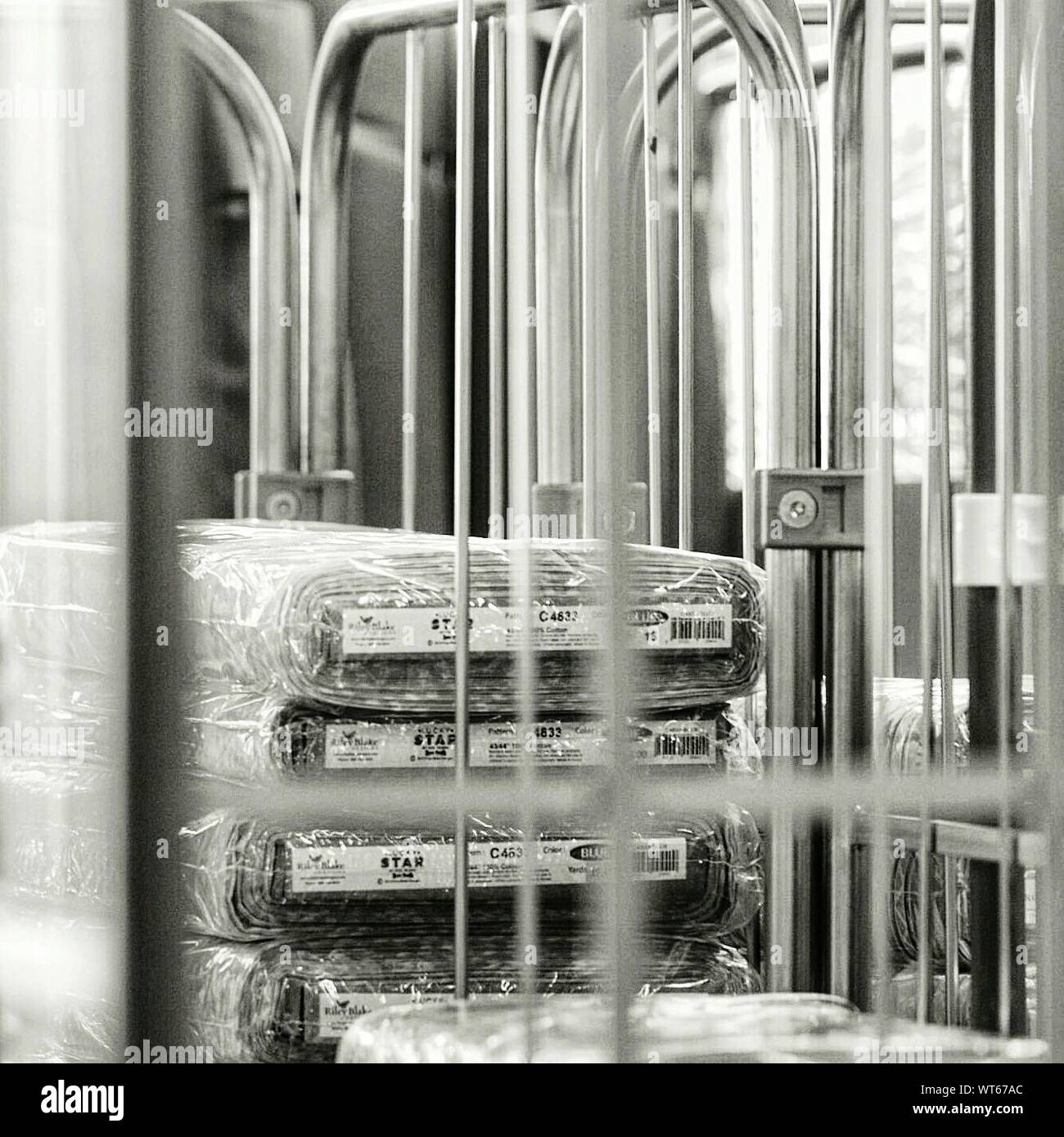 Stack Of Textile Packets Seen Through Metal Railing Stock Photo - Alamy